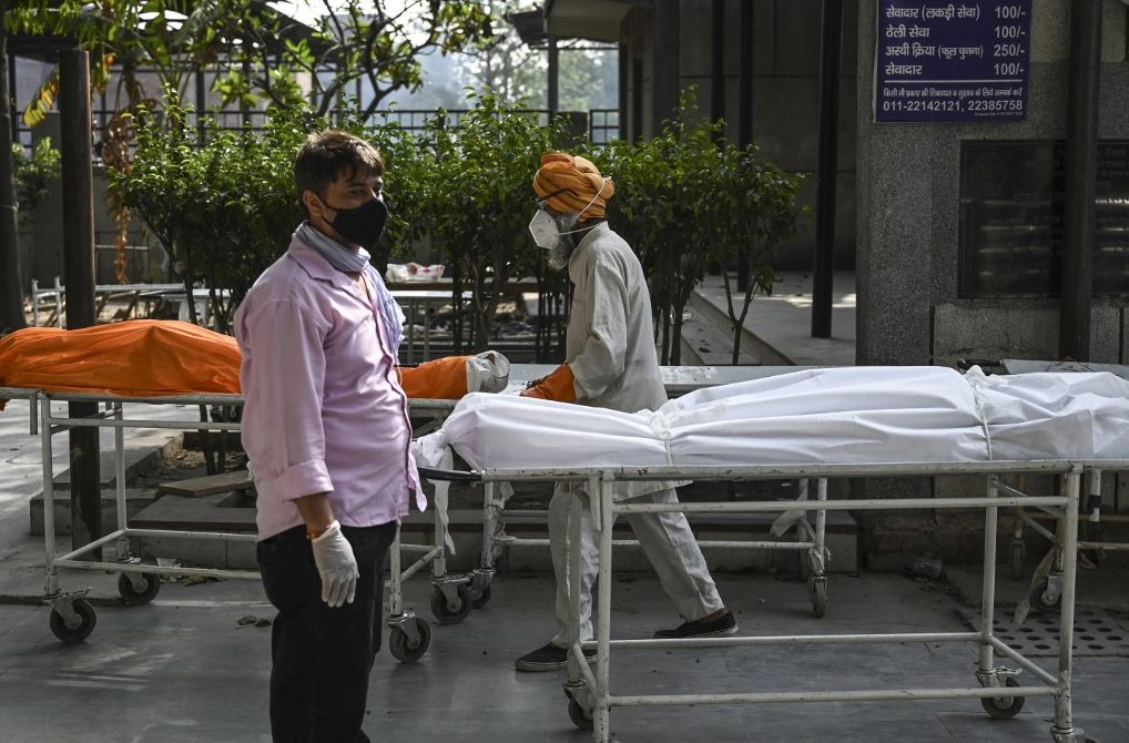 Voluntarios llevan los cuerpos de víctimas del covid-19 a un crematorio en Nueva Delhi. (Foto: Arun SANKAR / AFP)