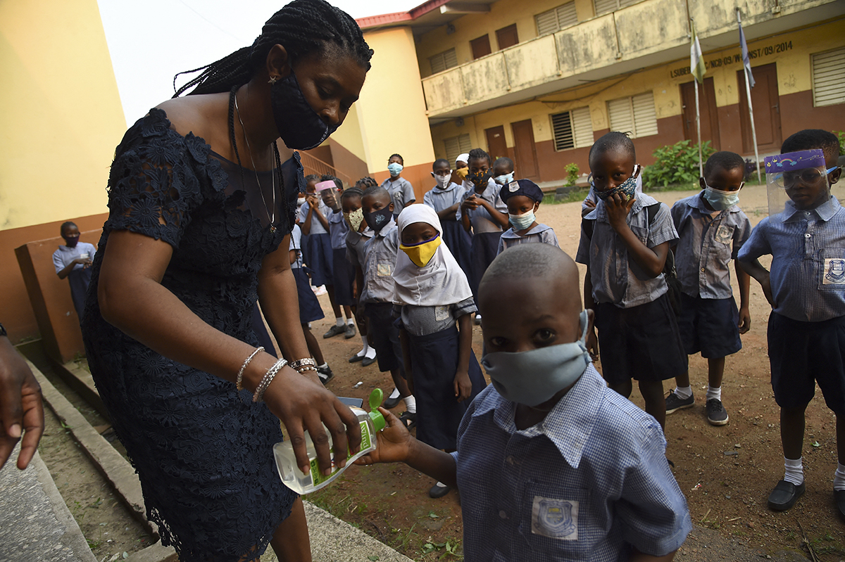 Una maestra aplica desinfectante de manos a un alumno en una primaria de Lagos, Nigeria, en enero de 2021. (Foto: Pius Utomi Ekpei/AFP)
