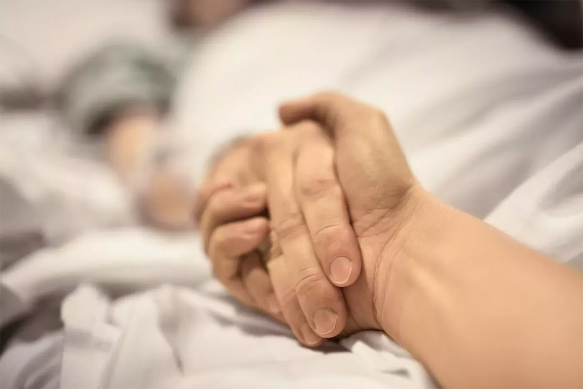 Archivo. Una persona sostiene la mano de un paciente hospitalizado. (Foto: Getty Images)