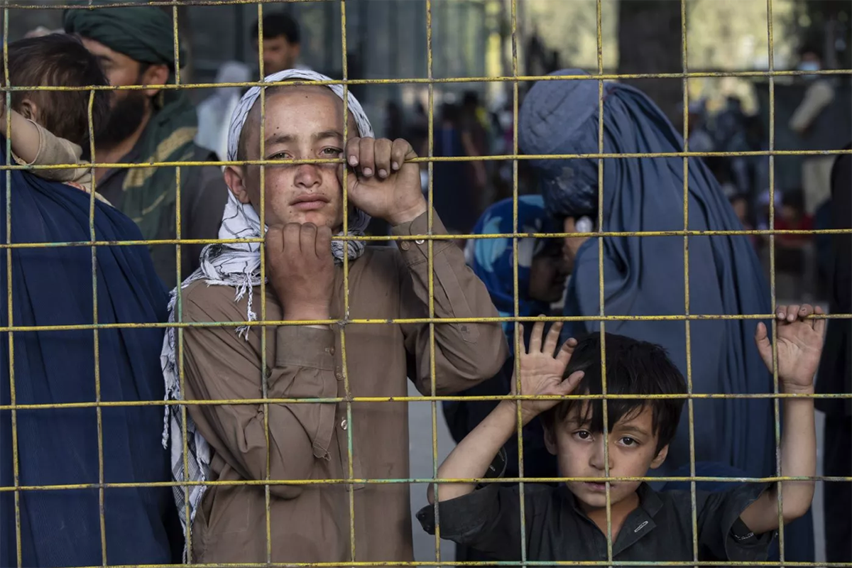 Afganos desplazados miran a través de una cerca en un campamento improvisado en Kabul, Afganistán. (Foto: Paula Bronstein/Getty)