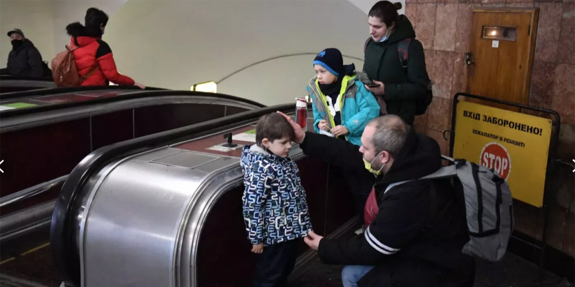 Alexander tranquiliza a su hijo mientras él y su familia se refugian en una estación del metro de Kiev, la mañana de este 24 de febrero. (Foto: Daniel Leal/AFP)