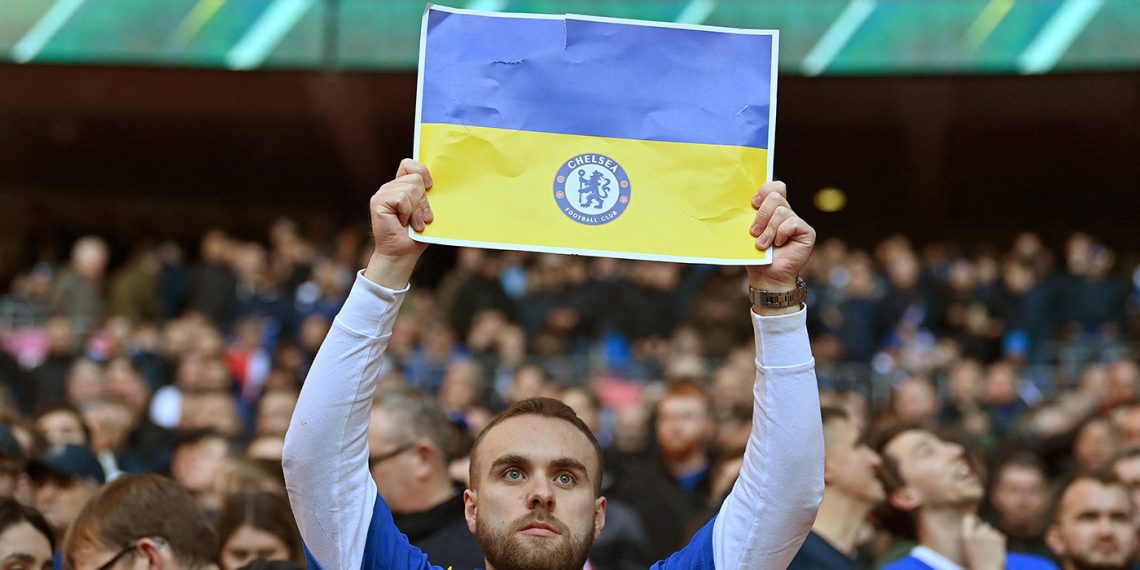 Seguidores del Chelsea sostienen banderas ucranianas en un partido de futbol, el 27 de febrero. (Foto: Glyn Kirk/AFP)