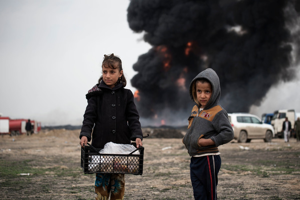 Los niños llevan comida a los bomberos mientras intentan extinguir los pozos de petróleo incendiados por los miembros de ISIS mientras se retiraban, en Qayyara, Irak. (Foto: Unicef)