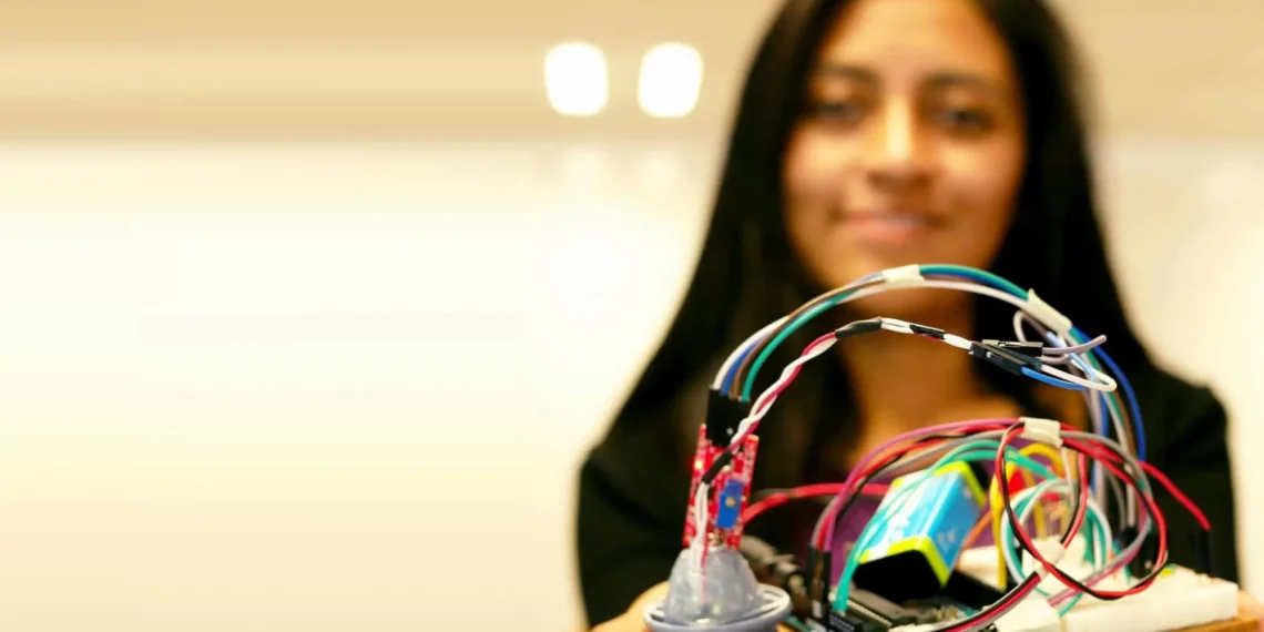 Emprendedora mostrando la placa de circuitos de un prototipo version alfa