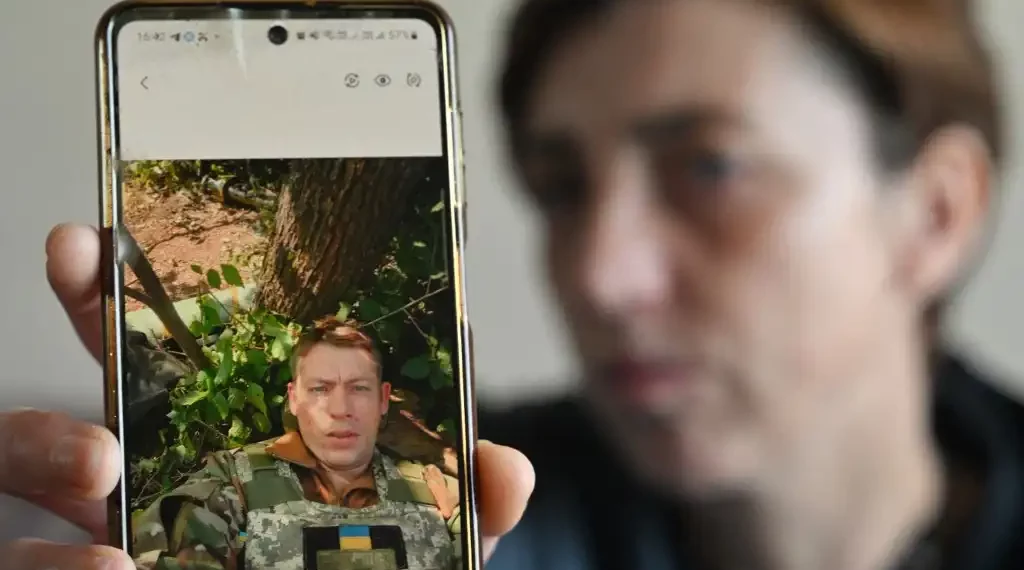 Svitlana Povar muestra en su celular una fotografía de su difunto esposo, el soldado ucraniano Semen Povar durante una entrevista. (AFP)