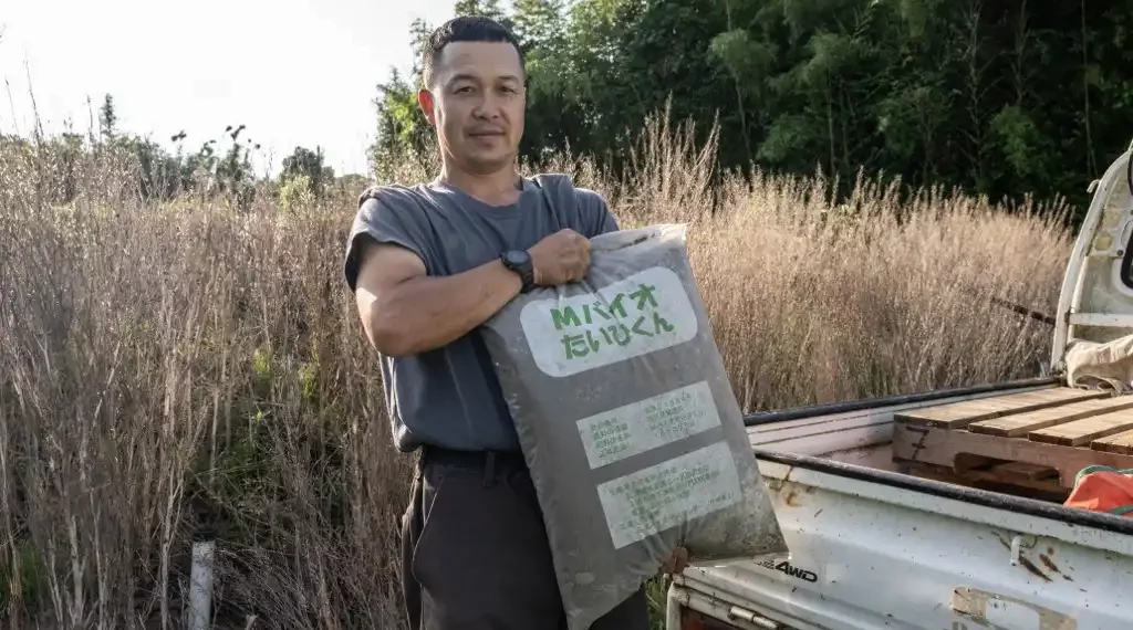 Esta fotografía muestra a Nobuyoshi Fujiwara, propietario de una granja de lechugas, posando para fotografías con una bolsa de fertilizante hecho con heces humanas en su granja en la ciudad de Yokosuka. (AFP)
