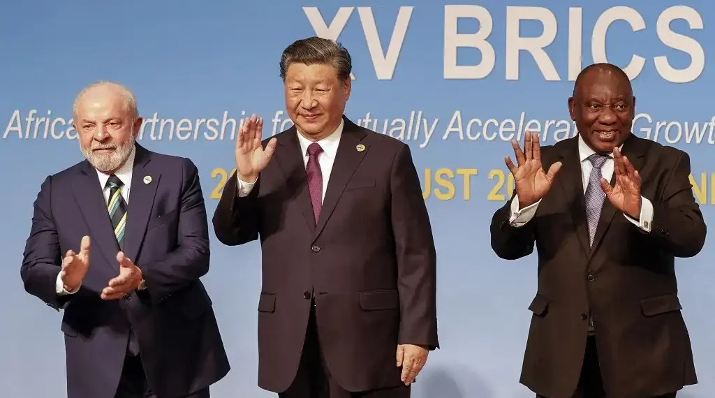 (De izquierda a derecha) El presidente de Brasil, Luiz Inácio Lula da Silva; el mandatario de China, Xi Jinping, y el presidente sudafricano, Cyril Ramaphosa, hacen un gesto durante la Cumbre BRICS de 2023. (AFP)