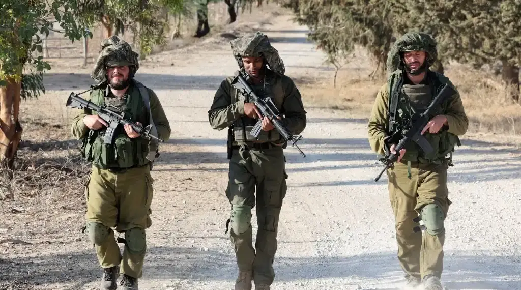 Tropas israelíes patrullan en un lugar no revelado a lo largo de la frontera con la Franja de Gaza el 19 de octubre. (AFP)