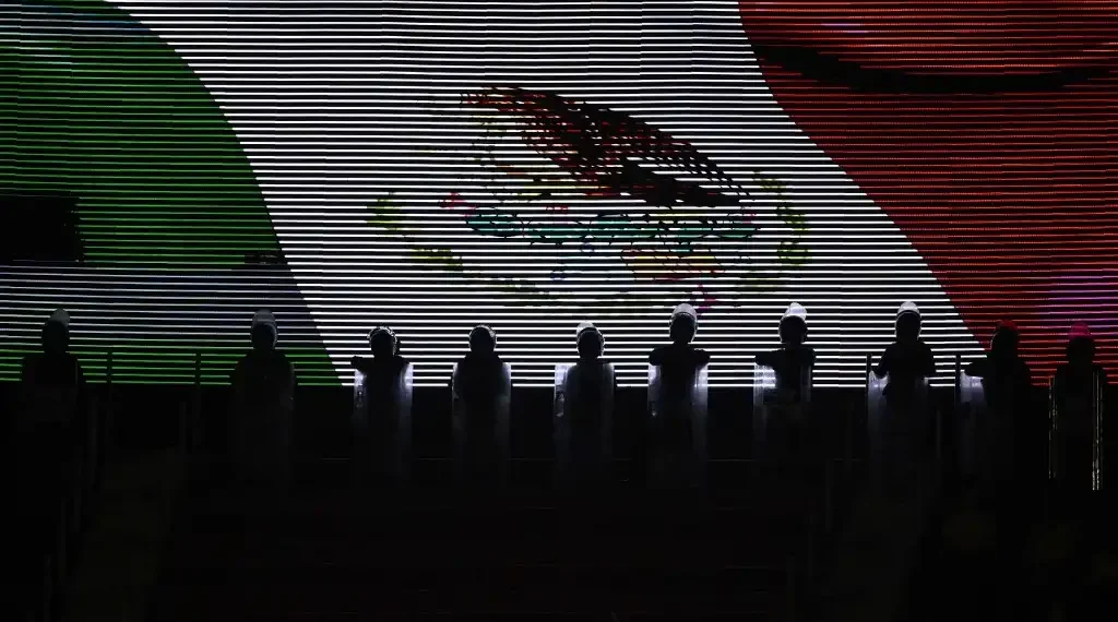 Una bandera mexicana se muestra en una pantalla durante un partido de futbol. (AFP)