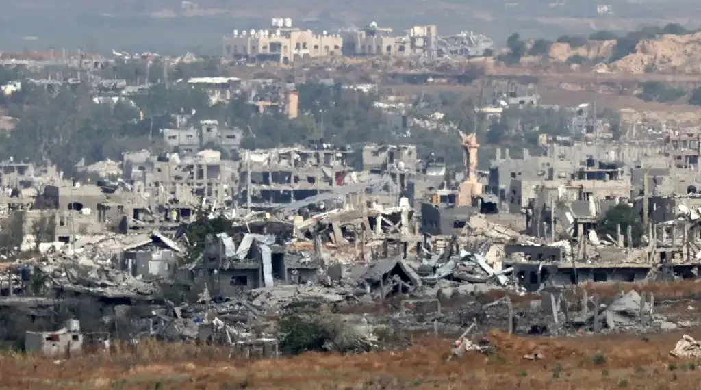 Esta fotografía tomada desde la frontera sur de Israel con la Franja de Gaza muestra edificios destruidos en el territorio palestino. (AFP)