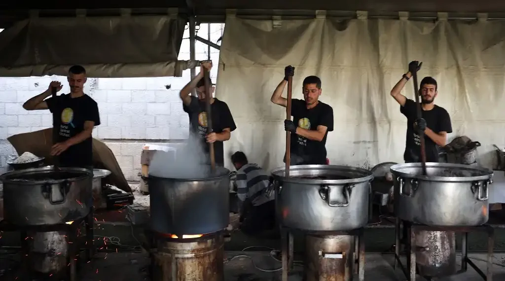 Los voluntarios locales de World Central Kitchen cocinan comidas que se distribuirán a los palestinos necesitados en Rafah, en el sur de la Franja de Gaza. (AFP)