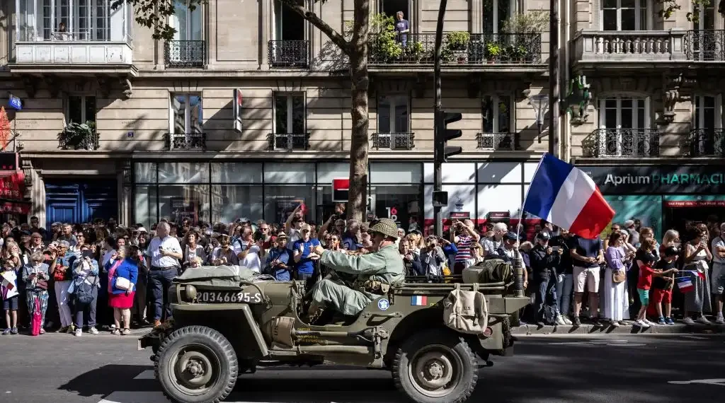 Recreadores vestidos con uniformes de guerra desfilan en vehículos militares de la época, durante una recreación que conmemora el 80 aniversario de la liberación de París de los alemanes durante la Segunda Guerra Mundial. (AFP)