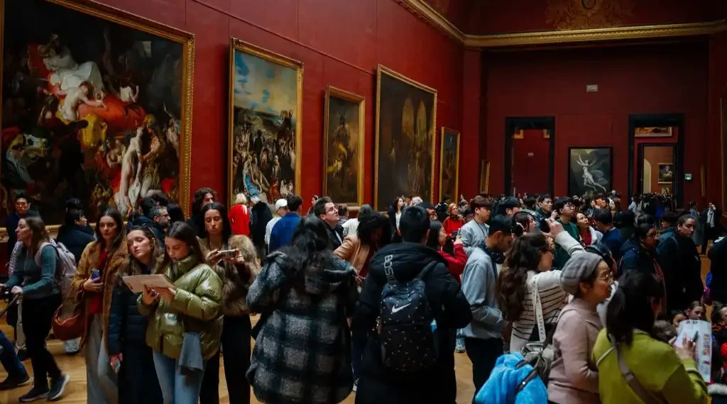 Los visitantes observan las pinturas del Museo del Louvre en París. (AFP)