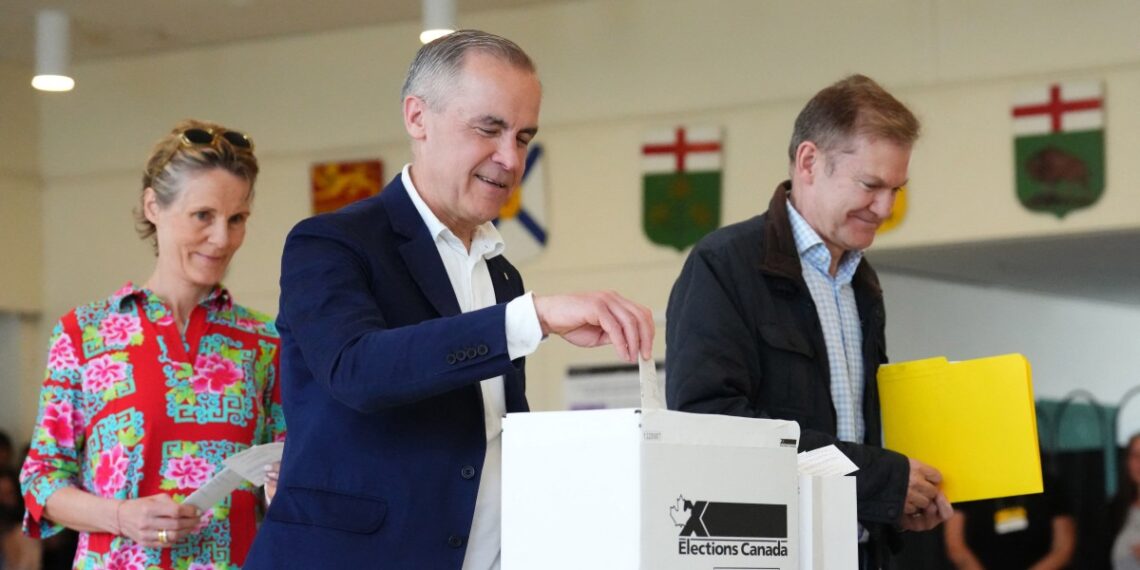 Mark Carney, PM canadiense y líder del Partido Liberal, emite su voto junto a su esposa Diana Fox Carney en Ottawa. (Photo by Sean KILPATRICK / POOL / AFP)