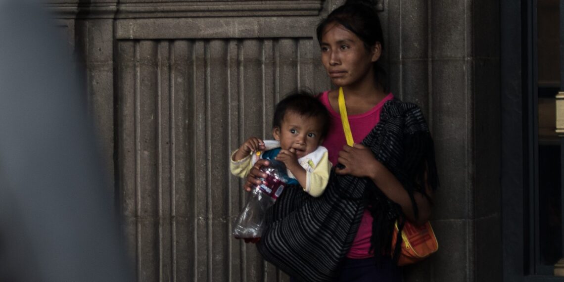 Mujer indígena espera junto con su bebé frente al Antiguo Palacio de Ayuntamiento. (FOTO: ANDREA MURCIA /CUARTOSCURO.COM)
