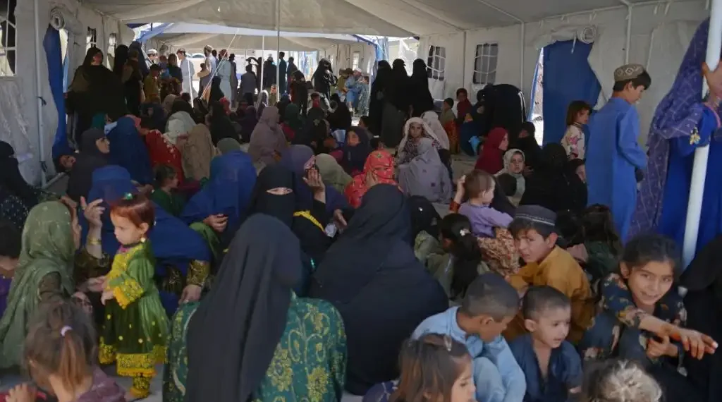 Refugiados afganos se sientan en una tienda de campaña a su llegada desde Pakistán, en un centro de registro en el distrito de Takhta Pul, provincia de Kandahar. (AFP)