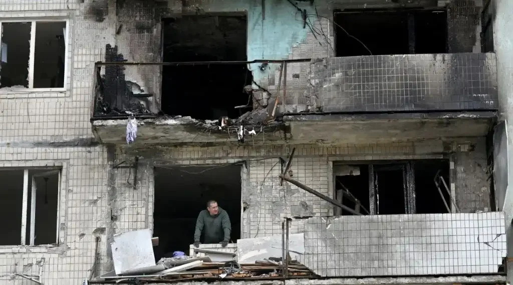 Un residente de un edificio dañado observa mientras limpia los escombros tras el ataque ruso en Kiev el 24 de mayo, en medio de la invasión rusa a Ucrania. (AFP)