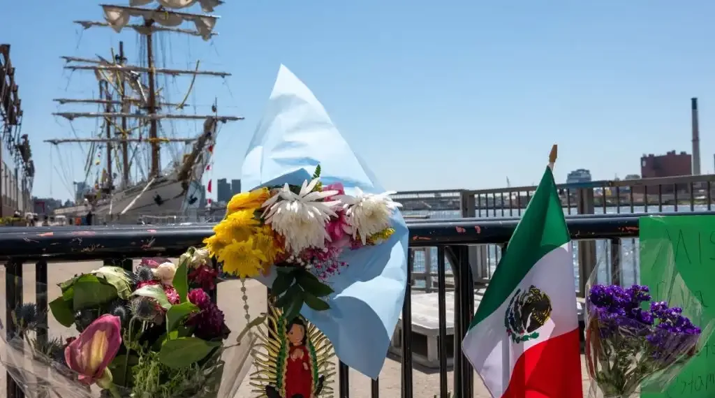 Flores y banderas se colocan en la entrada del velero Cuauhtémoc de la Armada de México, que se estrelló contra el Puente de Brooklyn durante el fin de semana en el bajo Manhattan. (AFP)