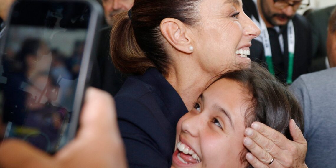 Claudia Sheinbaum en un encuentro con migrantes en su viaje hacia la cumbre del G7 en Canadá. (Photo by Dave Chidley / AFP)