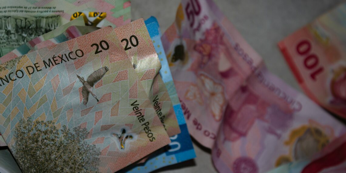 Billetes mexicanos de 20, 50 y 100 pesos en una superficie. Imagen que simboliza el impacto de la inflación en el valor del dinero en México.