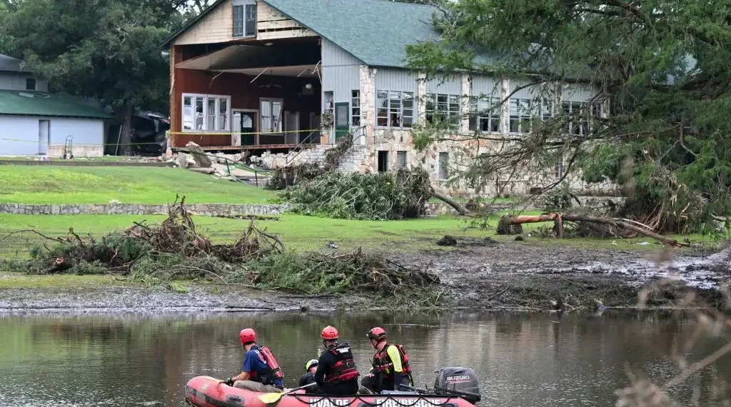 Un equipo de búsqueda y rescate busca personas a lo largo del río Guadalupe, cerca de un edificio dañado en Camp Mystic, en Hunt, Texas. (AFP)