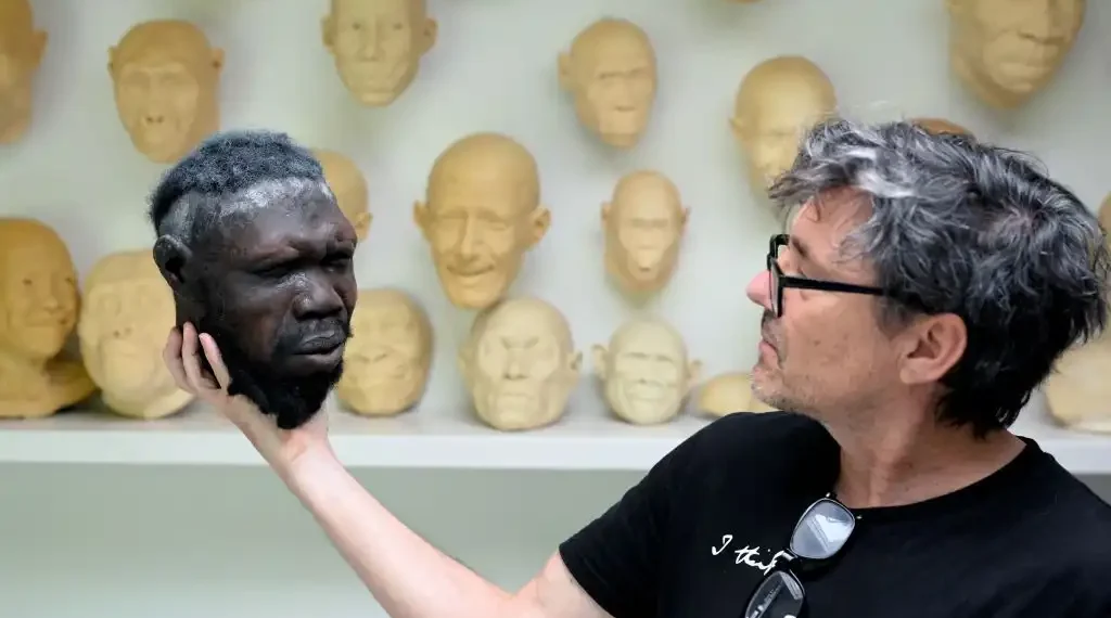 El artista holandés Alfons Kennis sostiene una maqueta en construcción que representa un cráneo humano prehistórico en su taller de Arnhem, países bajos. (AFP)